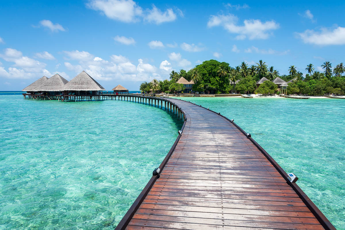 Boardwalk in the Maldives with over water bungalows in the distance.