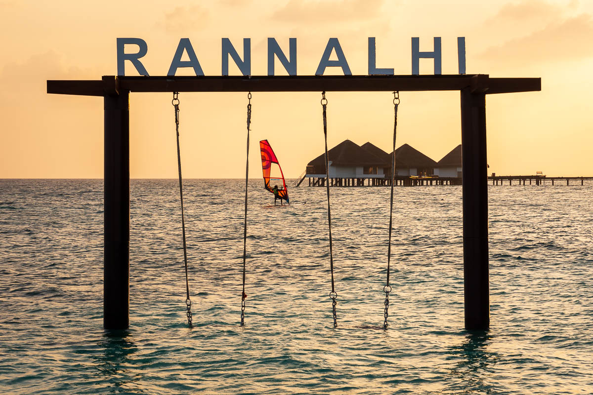 Windsurfer at sunset between the swings at Rannalhi resort. 
