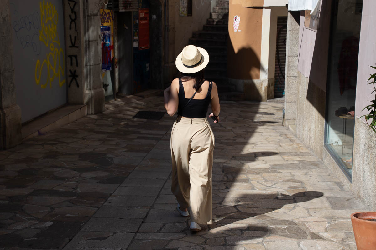 a woman strolling down the street in Palma De Mallorca. 