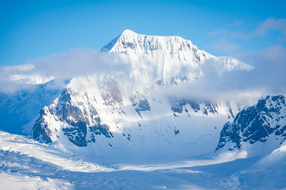 A snowy mountain top in light clouds in the Lemaire Channel.