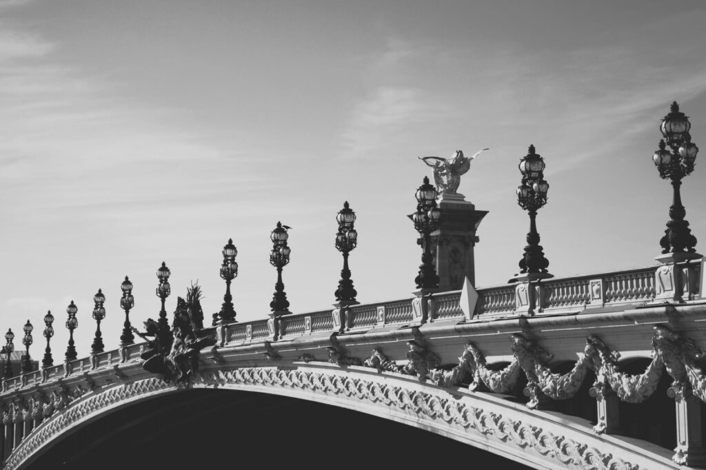 Elegant black and white image of Pont Alexandre III in Paris, showcasing architectural details.