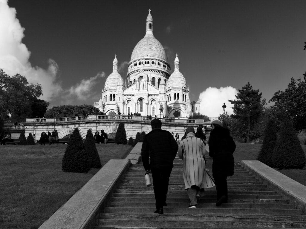 Black and white image of people walking up steps to Sacré-Cœur Basilica in Paris.