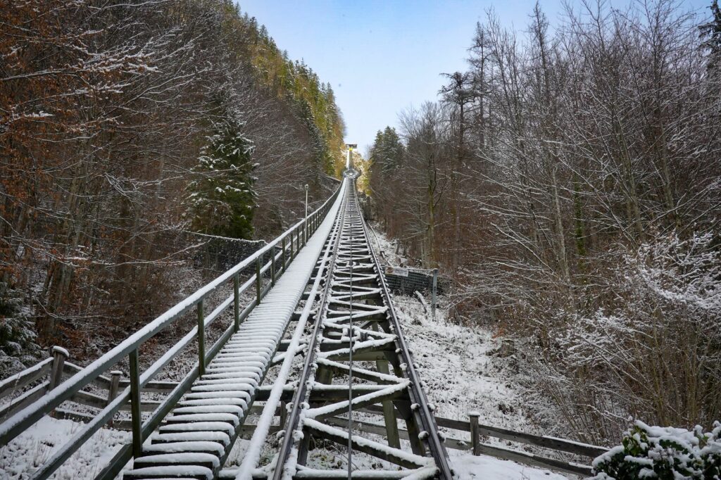 Picturesque snowy railway through Hallstatt's winter forest, Austria.