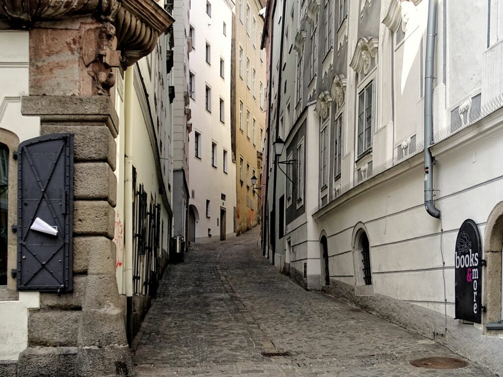 Explore the picturesque narrow alley in Linz with historic architecture and cobblestone path.