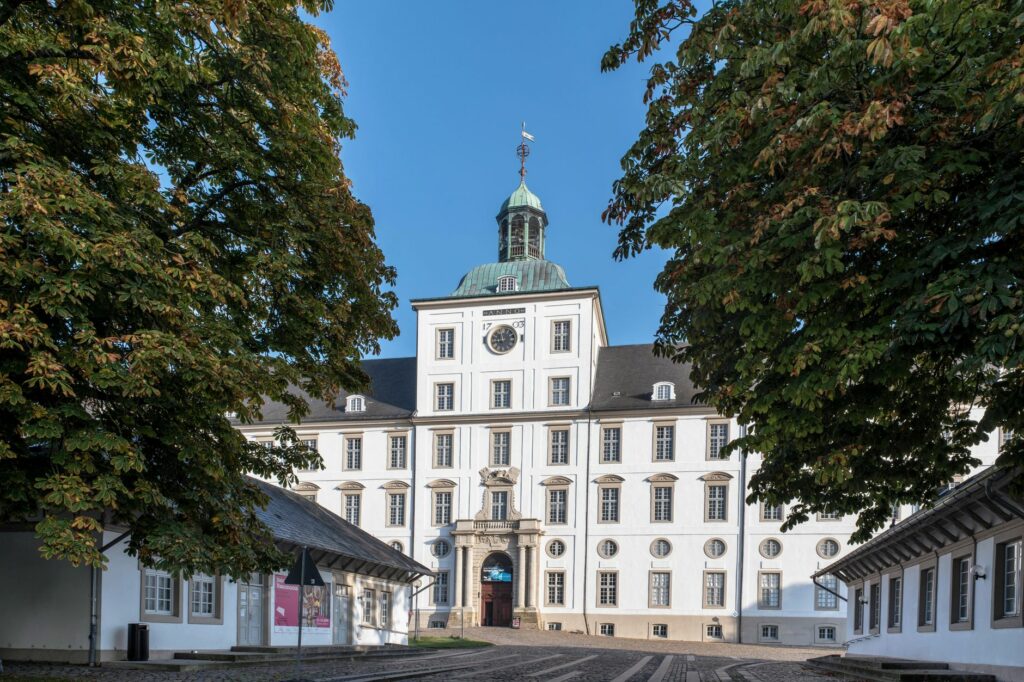 Discover the elegance of Gottorf Castle in Schleswig, Germany, framed by lush greenery and clear skies.
