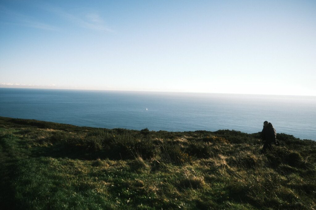 Serene view of the Irish coastline near Dublin with a lone hiker enjoying the natural beauty.