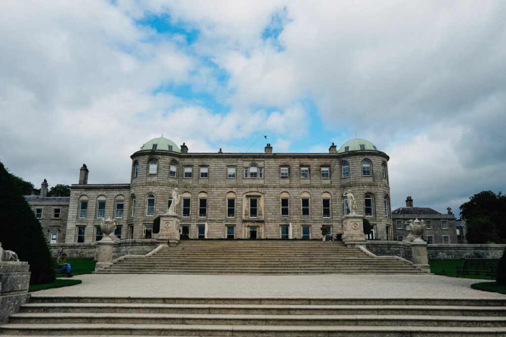 Majestic view of a historic mansion with stone steps under a cloudy sky, perfect for architectural enthusiasts.