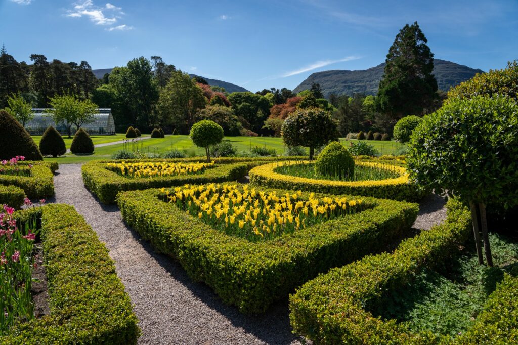 Beautifully manicured garden at Irish estate with scenic mountain view.