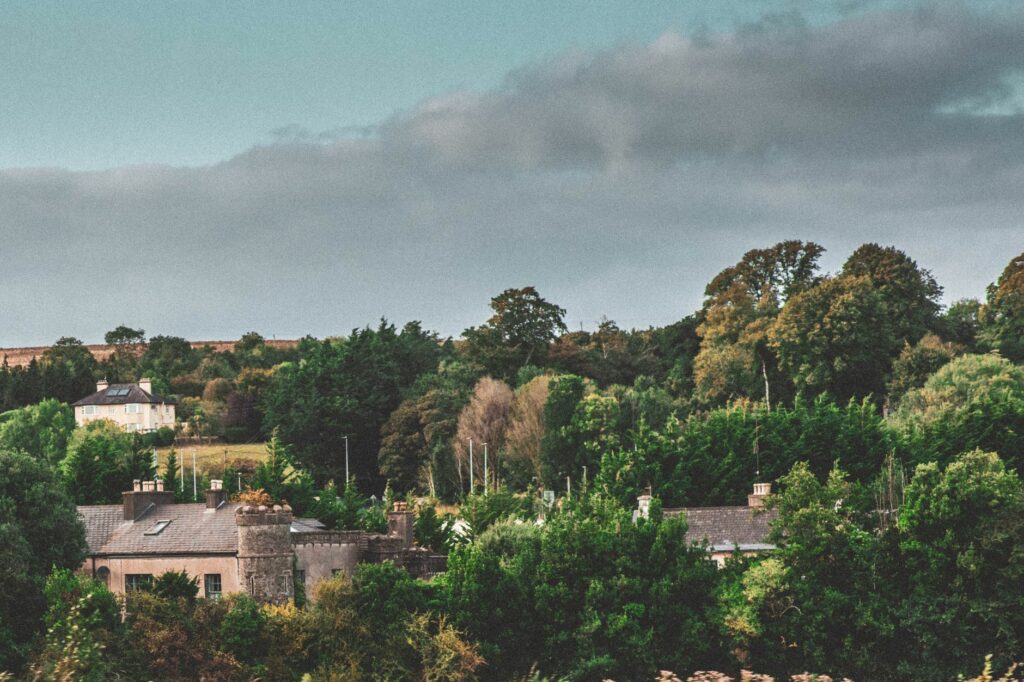 Picturesque view of historic buildings amidst lush greenery in Cork, Ireland.