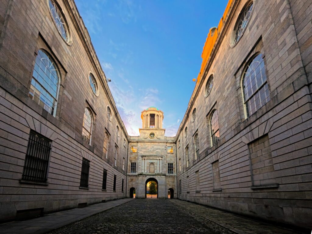 Symmetrical view of a historic building alley under a colorful dawn sky, showcasing classic architecture.