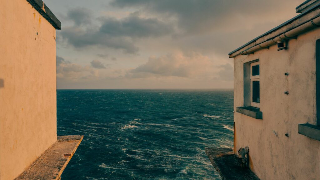 Captivating ocean view between two seaside buildings in Goleen, Ireland.