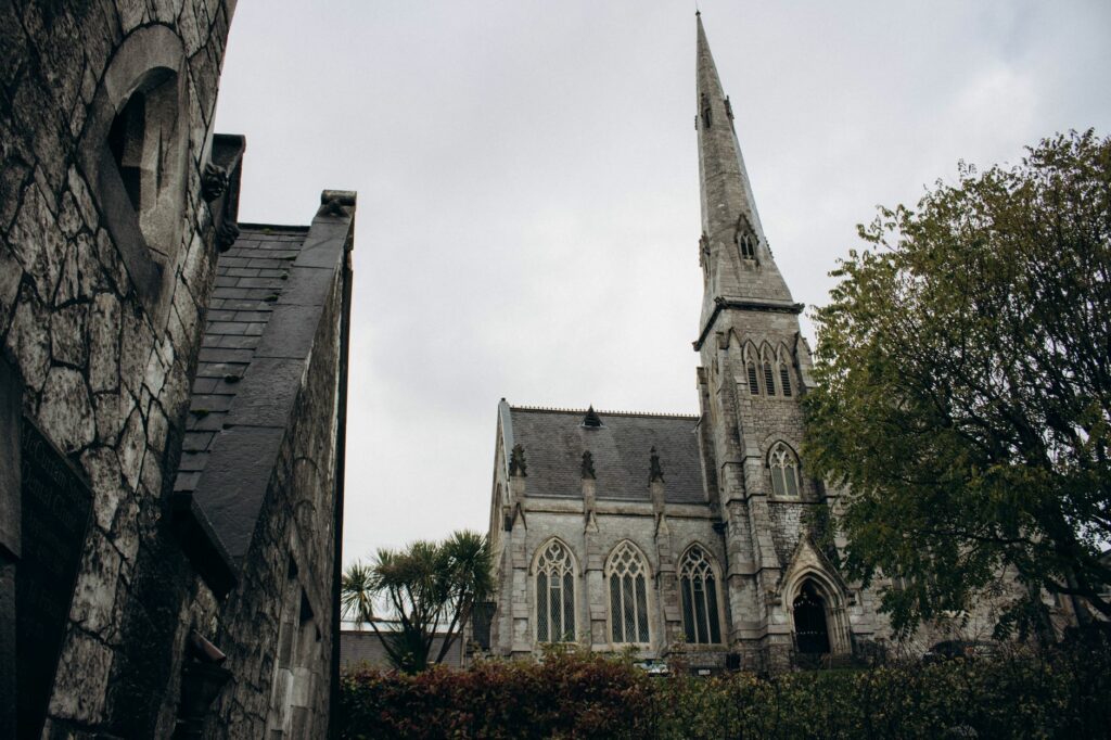 Majestic Gothic cathedral in Cork, Ireland showcasing intricate architecture under a cloudy sky.