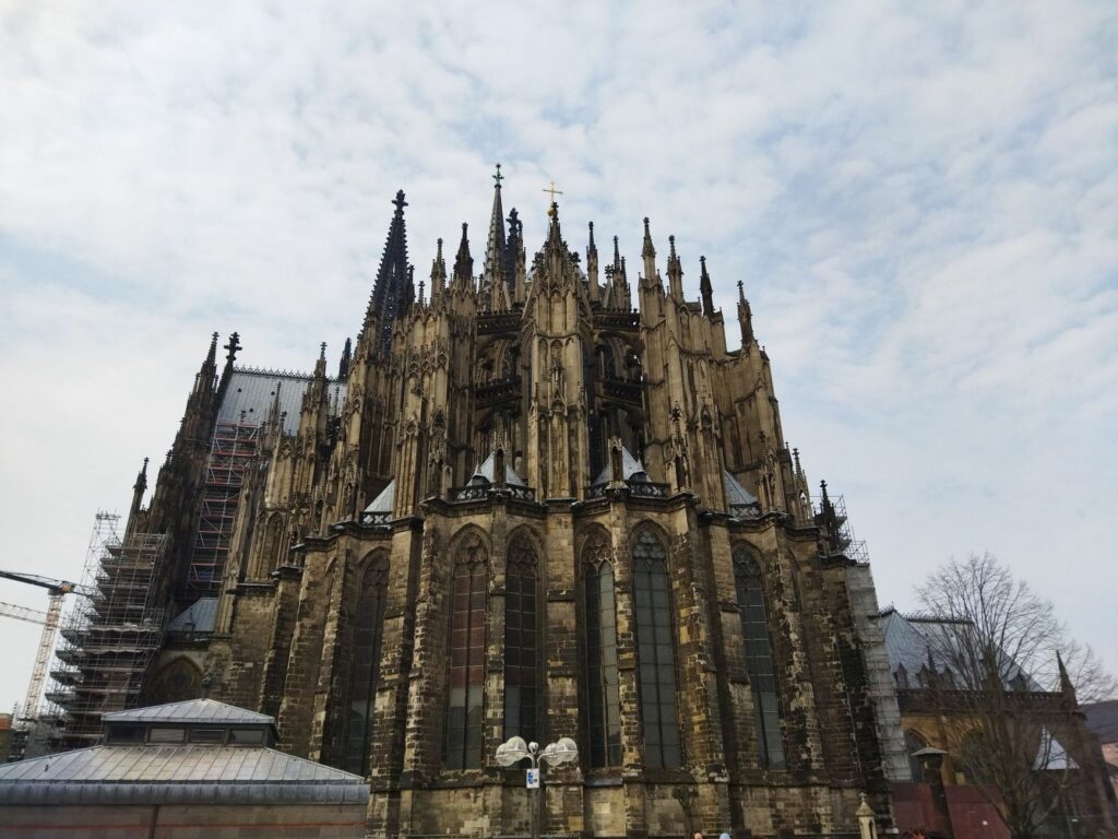 Majestic view of the detailed Gothic architecture of a historic cathedral under a cloudy sky.