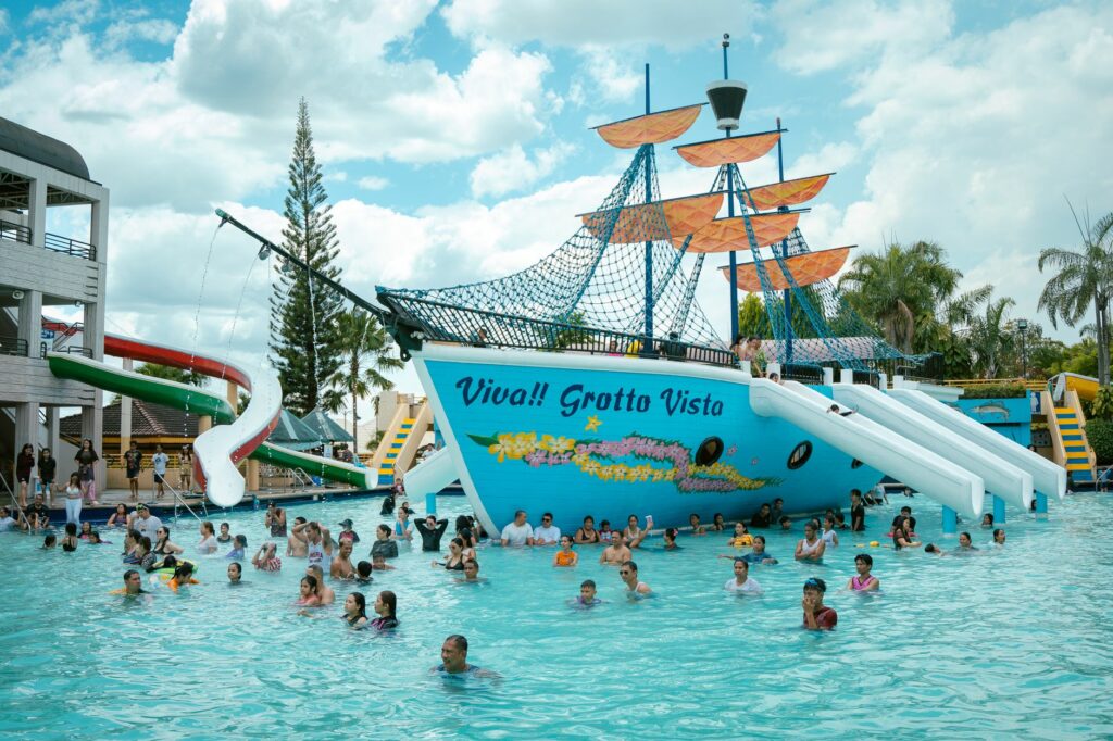 Families enjoying the swimming pool at Grotto Vista Resort under bright skies.