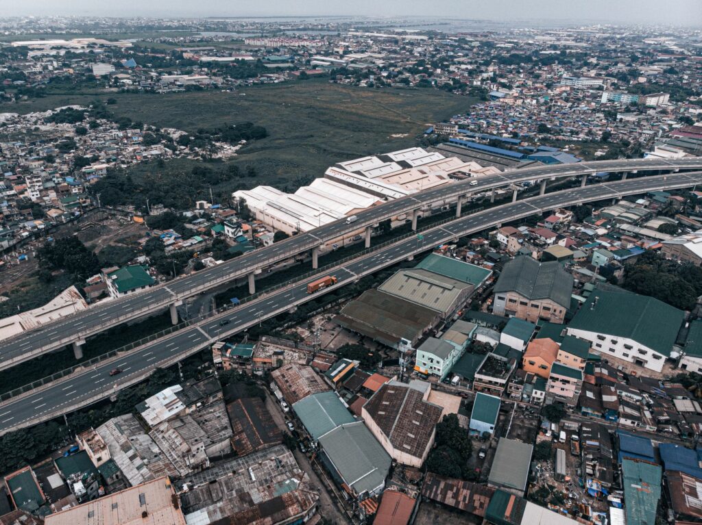 A vibrant aerial view of a bustling cityscape and elevated highway in the Philippines.
