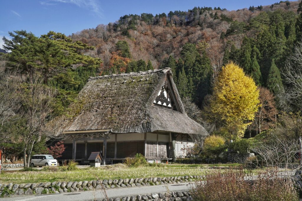 Scenic view of a gassho-style house in a Japanese village during fall.