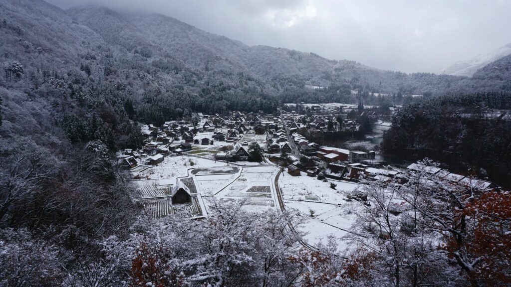 Aerial view of snowy Shirakawa village surrounded by mountains in winter, Gifu, Japan.