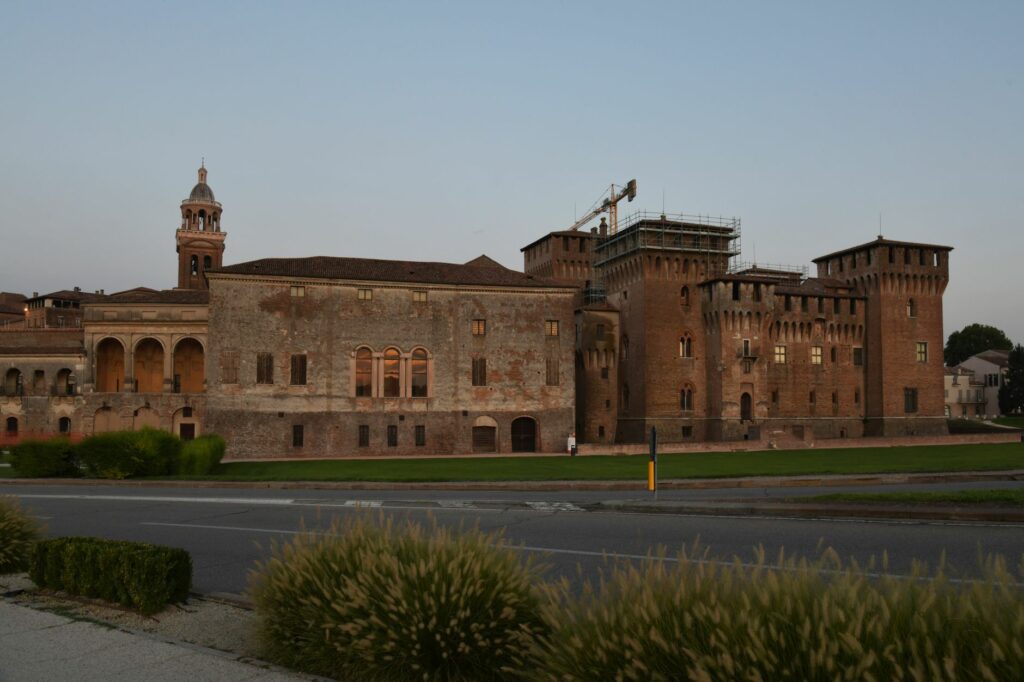 Charming view of a historic castle in Mantova, Italy, captured at dusk, highlighting its old brick facade.