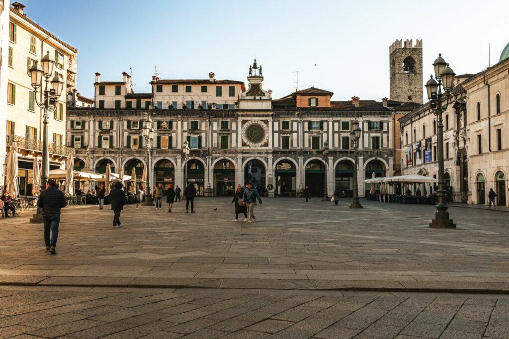 View of the Historic Piazza della Loggia in Brescia with people enjoying a sunny day.