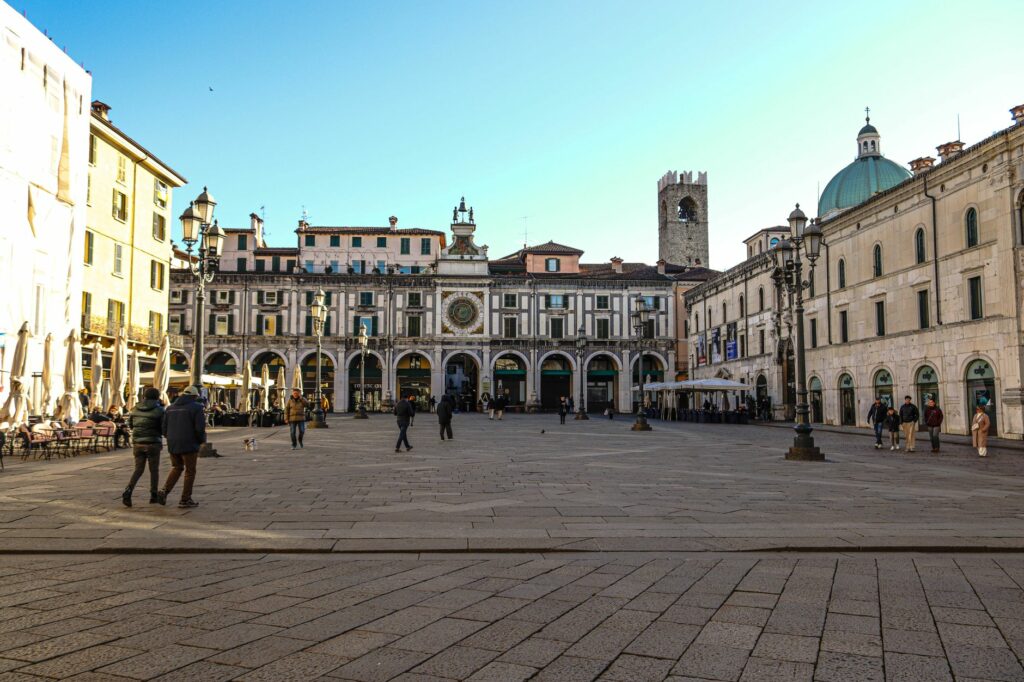 Beautiful sunny day at a historic plaza with a clock tower in Italy.