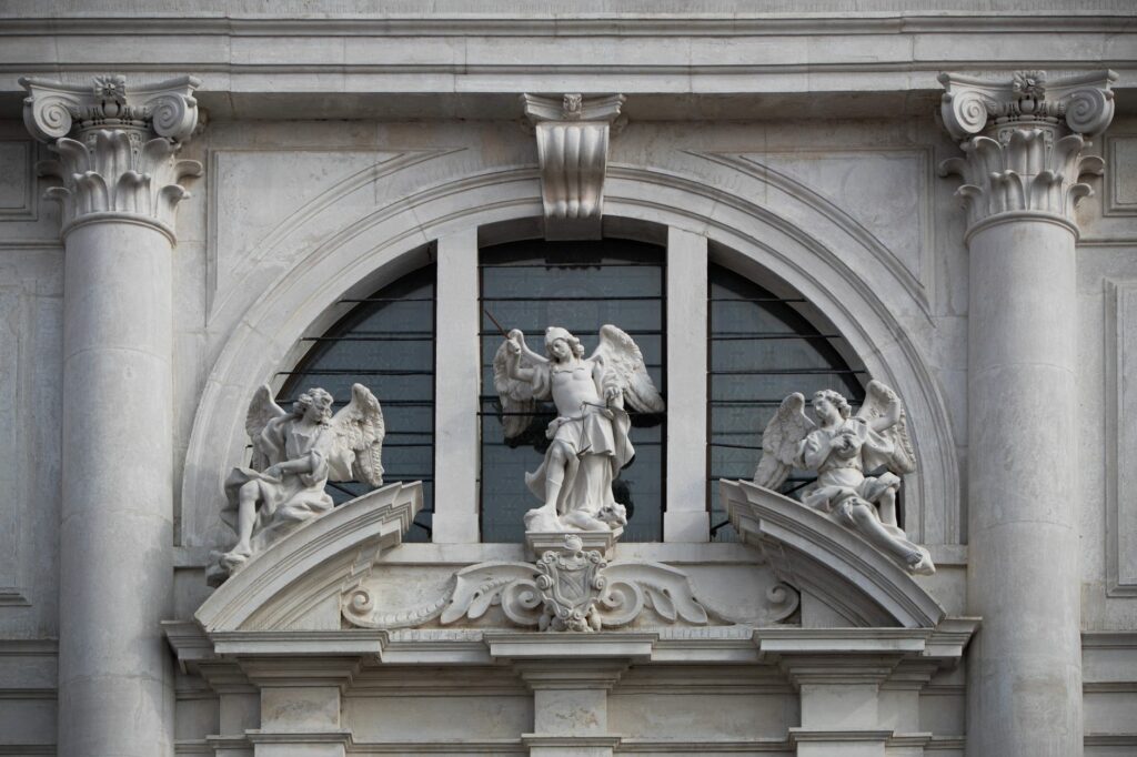 Close-up of angel statues on a church facade in San Daniele del Friuli, Italy.