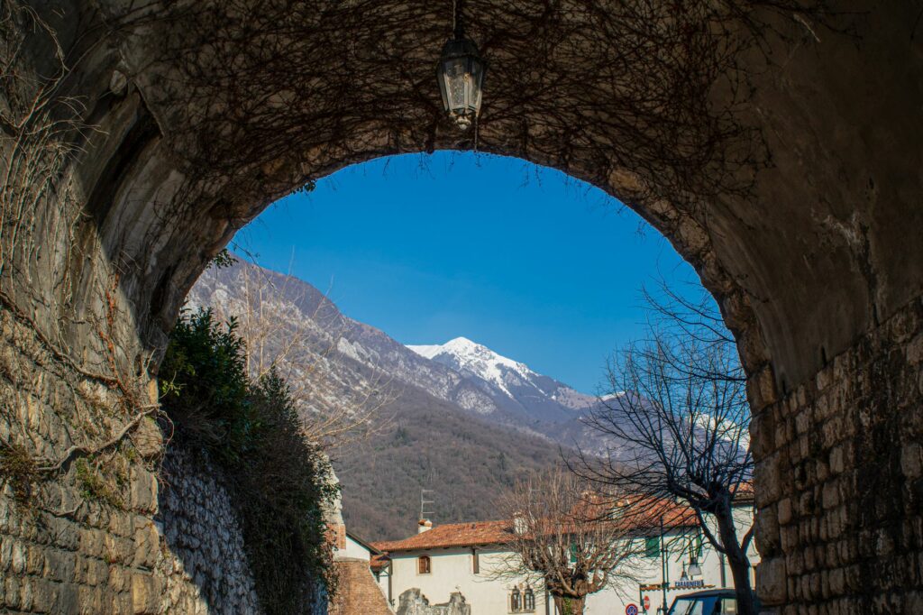 A stunning winter landscape viewed through an archway in Venzone, Italy.