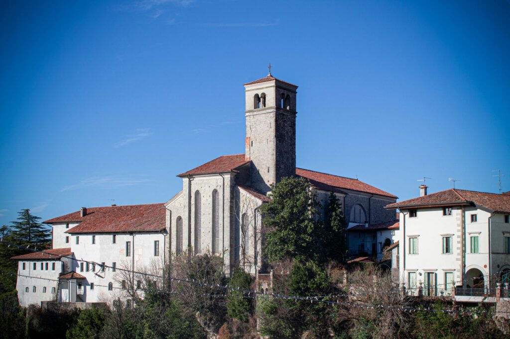 A picturesque view of a bell tower and buildings in Cividale del Friuli, Italy.
