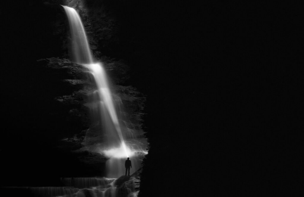 Striking black and white waterfall with silhouette in Brennero, Italy.