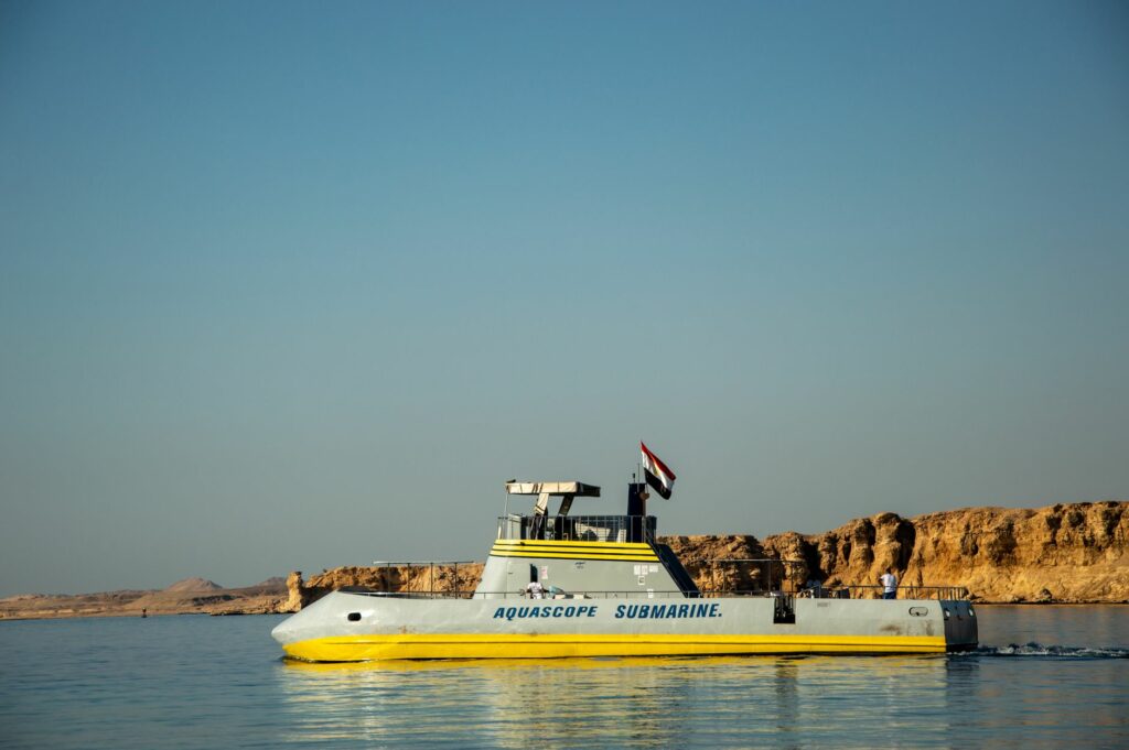 Aquascope submarine navigating the clear waters of the Red Sea with Egyptian coastline view.