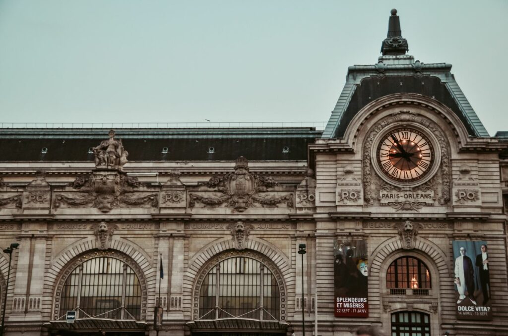 View of the iconic Gare d'Orsay building facade with its famous clock in Paris, France.