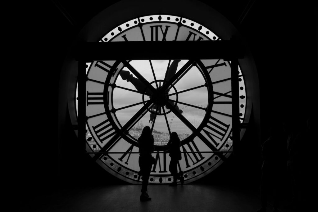 Silhouettes of people behind the famous Musée d'Orsay clock in Paris, France. Iconic landmark view.