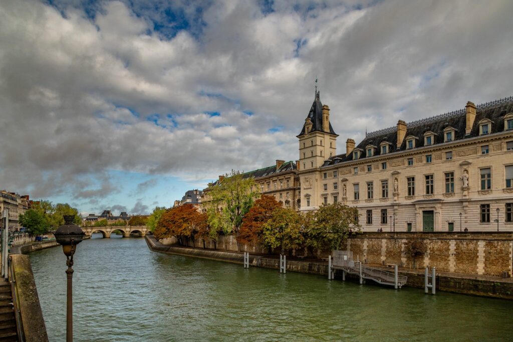 Explore the historic architecture along the Seine River in Paris, France under a dramatic sky.