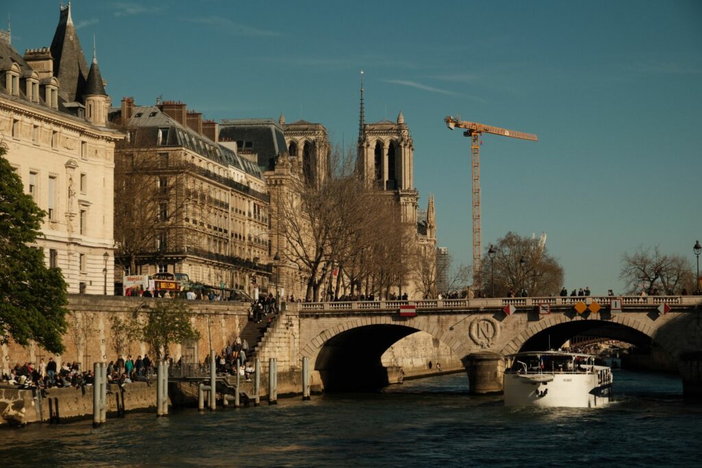 A picturesque scene of Notre-Dame Cathedral beside the Seine River on a sunny day in Paris.