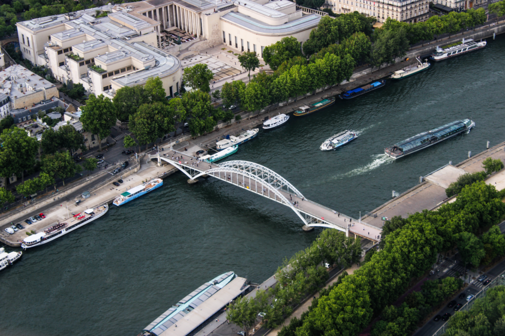 An aerial shot of the Seine River showcasing boats and a bridge in Paris, France.